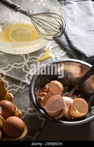 Kochen mit Eiern, zerrissenen Eierschalen, gebrauchten Küchenutensilien auf dem Tisch Stockfoto