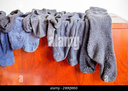 Gewaschene schwarze Herrensocken aus Wolle auf dem Schrank. Reinigung des Hauses Stockfoto