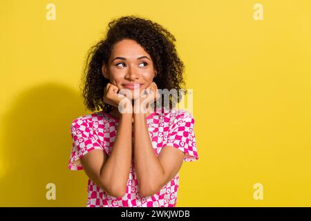 Porträt der liebenswerten Dame Hände berühren Wangen sehen leer aus Stellen Sie sich isoliert auf gelbem Hintergrund vor Stockfoto