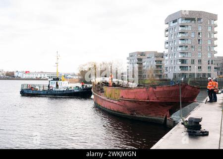 21. Februar 2024, Mecklenburg-Vorpommern, Rostock: Das Wrack des Seebad-Schiffes „Undine“ wird zum Schleppen im Stadthafen vorbereitet. Das Schiff, das seit zehn Jahren dort liegt, gilt als das älteste Seebad-Schiff Deutschlands. Sie wurde 1910 erbaut. Die „Undine“ wird vom Stadthafen zum Fischerhafen gezogen. Sie wird dann mit einem Kran aus dem Wasser gehoben und an Land gelegt. Nach Schätzungen Rostocks würde die Restaurierung des langjährigen Binnenschiffes 500.000 Euro Kosten - laut Hansestadt zu viel. Es ist also Current Stockfoto