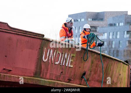 21. Februar 2024, Mecklenburg-Vorpommern, Rostock: Das Wrack des Seebad-Schiffes „Undine“ wird zum Schleppen im Stadthafen vorbereitet. Das Schiff, das seit zehn Jahren dort liegt, gilt als das älteste Seebad-Schiff Deutschlands. Sie wurde 1910 erbaut. Die „Undine“ wird vom Stadthafen zum Fischerhafen gezogen. Sie wird dann mit einem Kran aus dem Wasser gehoben und an Land gelegt. Nach Schätzungen Rostocks würde die Restaurierung des langjährigen Binnenschiffes 500.000 Euro Kosten - laut Hansestadt zu viel. Es ist also Current Stockfoto