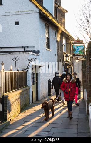 Eine Frau, die ihren Hund vor dem Dove Public House in Hammersmith, West London, England, Großbritannien begleitet Stockfoto