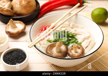 Köstliche Ramen mit Fleisch und Zutaten auf Holztisch, Nahaufnahme. Nudelsuppe Stockfoto