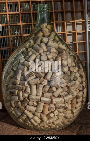Ein Glasdemijohn ist mit vielen Korken gefüllt Stockfoto
