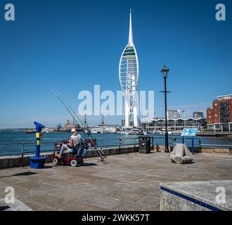 Leute fischen an einem sonnigen Tag in Old Portsmouth mit dem Spinnaker Tower im Hintergrund. Stockfoto