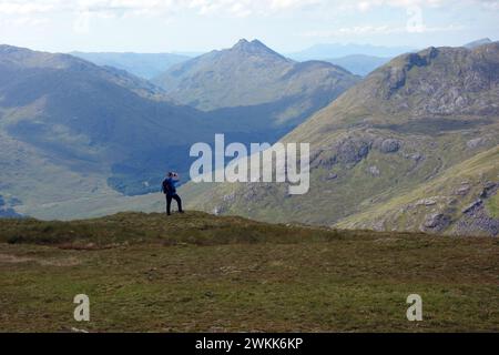 Mann (Wanderer) macht Fotos von Glen Dessarry und dem Corbett 'Bidean A' Chabair' aus dem Corbett 'Fraoch Bheinn' Scottish Highlands, Schottland, Großbritannien. Stockfoto