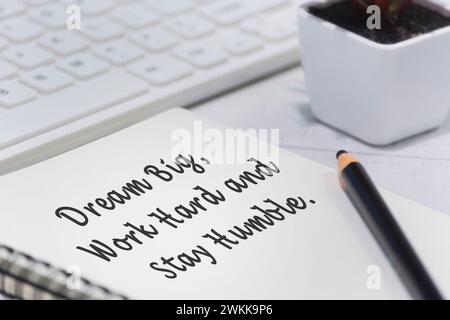 Motivierendes Zitat auf Notizblock – Träume groß, arbeiten hart und bleiben demütig. Stockfoto