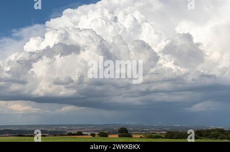 Schlechtes Wetter mit dunklen Wolken. Endlose grüne Felder. Cumulonimbus- und Cumulusbildung im Hochsommer mit Grünsaat. Stockfoto