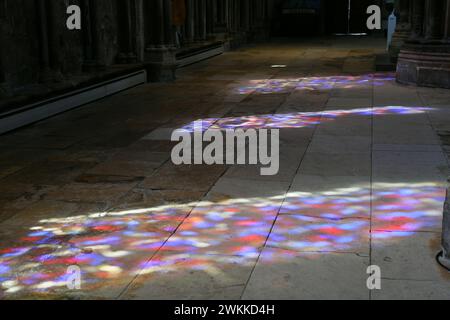 Farben und Muster von Buntglasfenstern spiegeln sich auf dem Boden der Lincoln Cathedral in Lincolnshire, England Stockfoto