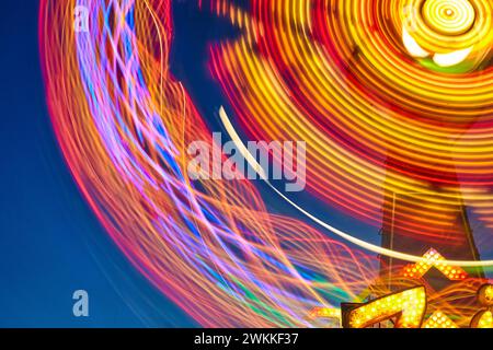 Twilight Amusement Park Ride in Motion, Long Exposure Lights Stockfoto