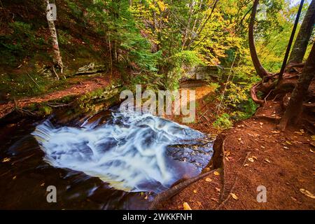 Herbststrom im Michigan Forest mit kaskadierendem Wasserfall Stockfoto