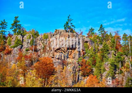 Herbstpracht der Cliff Mines: Felsiger Felsvorsprung und buntes Laub Stockfoto
