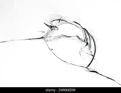 Loch mit Rissen in Glasstruktur auf weißem Hintergrund. Nahaufnahme. Stockfoto