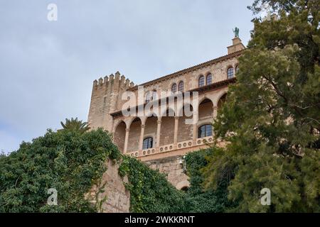 Blick von unten auf den Königlichen Palast von La Almudaina mit einigen Bäumen in Palma de Mallorca, Balearen, Spanien Stockfoto