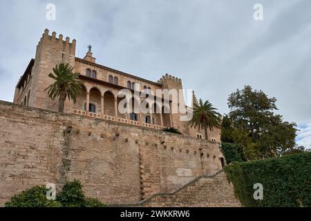 Blick von unten auf den Königlichen Palast von La Almudaina mit einigen Bäumen in Palma de Mallorca, Balearen, Spanien Stockfoto