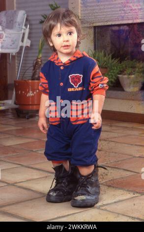 Austin Texas USA, 1995:19-monatiger Anglo Boy spielt in den großen schwarzen Schuhen seines Vaters. ©Bob Daemmrich Stockfoto