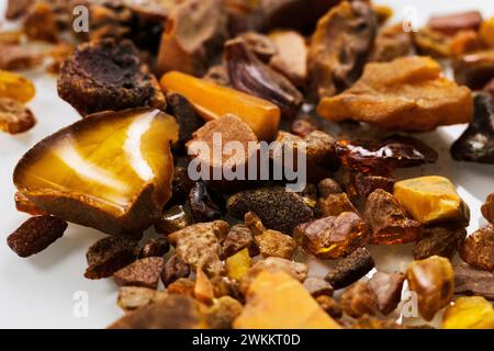 Gelbe und orangene rohe Bernsteinstücke unterschiedlicher Formen. Rohstoffe für Schmuck Stockfoto