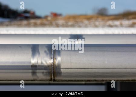 Edelstahlrohr Nahaufnahme der Schweißverbindung. Draußen im Sonnenlicht in einem Piperack. Stockfoto