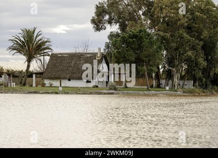 Ein charmantes Reetdachhaus steht am Ufer im Albufera Naturpark in der Nähe von Valencia und bietet einen ruhigen ländlichen Rückzugsort. Stockfoto