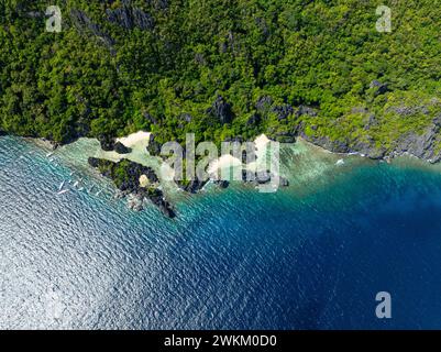 Blick von oben auf klares Wasser mit Sonnenspiegelung über Hidden Beach. Matinloc Island. El Nido, Philippinen. Stockfoto