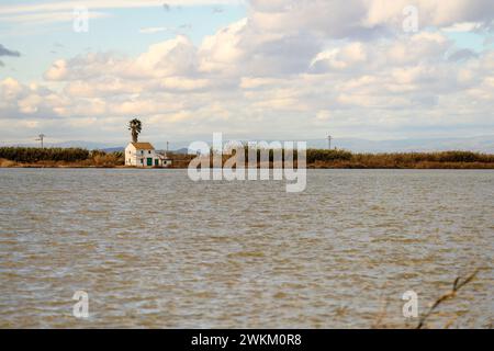 Ein charmantes Reetdachhaus steht am Ufer im Albufera Naturpark in der Nähe von Valencia und bietet einen ruhigen ländlichen Rückzugsort. Stockfoto