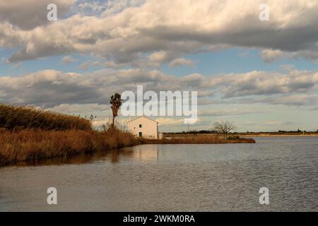 Ein charmantes Reetdachhaus steht am Ufer im Albufera Naturpark in der Nähe von Valencia und bietet einen ruhigen ländlichen Rückzugsort. Stockfoto