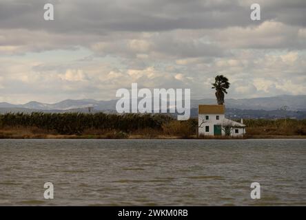 Ein charmantes Reetdachhaus steht am Ufer im Albufera Naturpark in der Nähe von Valencia und bietet einen ruhigen ländlichen Rückzugsort. Stockfoto