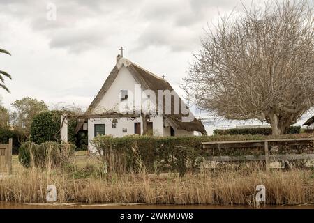 Ein charmantes Reetdachhaus steht am Ufer im Albufera Naturpark in der Nähe von Valencia und bietet einen ruhigen ländlichen Rückzugsort. Stockfoto