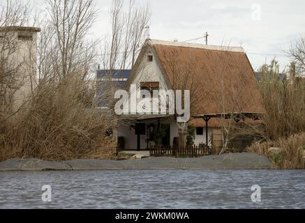 Ein charmantes Reetdachhaus steht am Ufer im Albufera Naturpark in der Nähe von Valencia und bietet einen ruhigen ländlichen Rückzugsort. Stockfoto