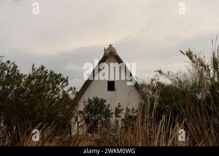 Ein charmantes Reetdachhaus steht am Ufer im Albufera Naturpark in der Nähe von Valencia und bietet einen ruhigen ländlichen Rückzugsort. Stockfoto