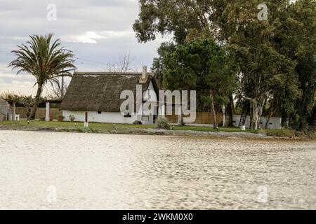 Ein charmantes Reetdachhaus steht am Ufer im Albufera Naturpark in der Nähe von Valencia und bietet einen ruhigen ländlichen Rückzugsort. Stockfoto