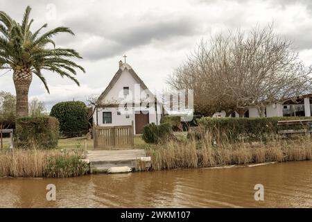 Ein charmantes Reetdachhaus steht am Ufer im Albufera Naturpark in der Nähe von Valencia und bietet einen ruhigen ländlichen Rückzugsort. Stockfoto