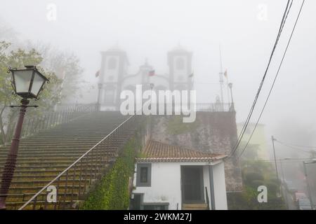 Die Igreja de Nossa Senhora do Monte, oder die Kirche unserer Lieben Frau von Monte, die in Nebel gehüllt ist, in der auf einem Hügel gelegenen Stadt Monte, Portugal, auf der Insel Madeira Stockfoto