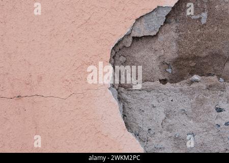 Von der Wand herabfallender Gips. Reparaturen von schlechter Qualität. Zerbröckelndes Fassadengebäude Stockfoto