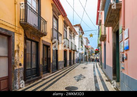 Eine malerische Gasse mit historischen Steinhäusern auf einer Kopfsteinpflasterstraße in der historischen Altstadt von Funchal, Portugal, auf der Kanarischen Insel Madeira Stockfoto