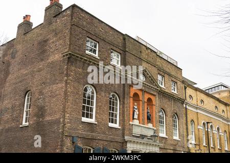 Coade Stone Stollen vor der ehemaligen Bluecoat Charity School im St Johns Old School House, Scandrett Street, Wapping, London, E1, England, Großbritannien Stockfoto