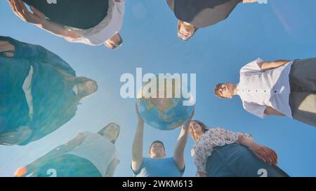 Das Konzept, die Welt zu schützen. Freunde, die einen geografischen Globus in den Händen halten. Stockfoto