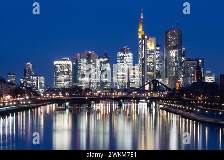 21. Februar 2024, Hessen, Frankfurt/Main: Die Lichter der Bank-Skyline von Frankfurt am Main leuchten im letzten Licht des Tages. Foto: Boris Roessler/dpa Stockfoto