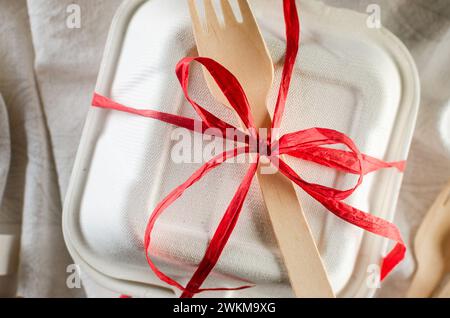 Weiße bento-Kuchenbox mit roter Schleife. Geschenkbox mit leckerem bento. Kuchenverpackung. Lieferung. Stockfoto