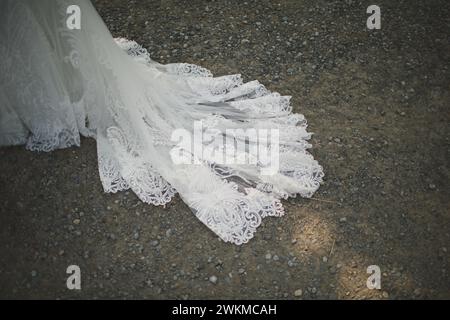 Eine Braut in Hochzeitsschleier und Kleid auf dem Boden Stockfoto