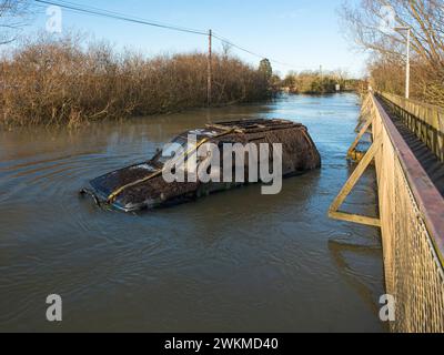 Verlassenes Auto in Hochwasser am Sutton Gault Causeway, Ouse Washes, Cambridgeshire, England Stockfoto