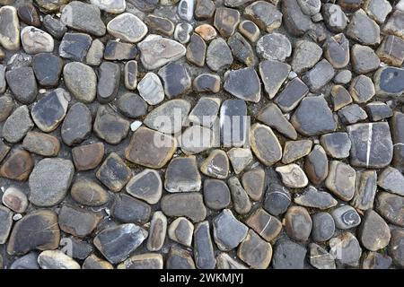 Stadtmuster – Bürgersteig mit vielen flachen Steinen Stockfoto