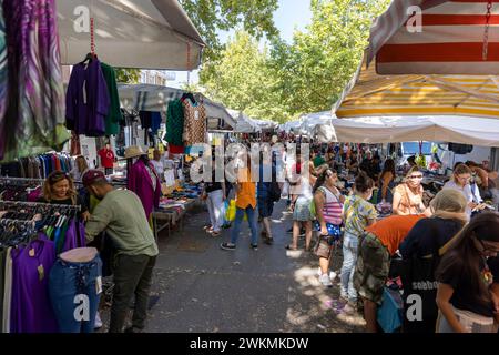 Shopping auf Flohmärkten, die die Straßen des Navigli-Viertels von Mailand säumen, wo die Stände mit Kleidung und Accessoires voll mit Einheimischen sind. Stockfoto