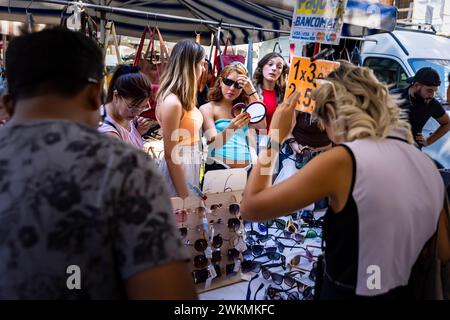 Shopping auf Flohmärkten, die die Straßen des Navigli-Viertels von Mailand säumen, wo die Stände mit Kleidung und Accessoires voll mit Einheimischen sind. Stockfoto