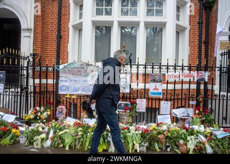 London, Großbritannien. Februar 2024. Ein Mann betrachtet Blumen, Tribut und Bilder von Alexej Nawalny, während er am Boris Nemstov Place gegenüber der russischen Botschaft in London vorbeigeht. Alexej Nawalny, 47 Jahre alt, starb am 16. Februar 2024 in der arktischen Strafkolonie nach seinem Morgenspaziergang nach der offiziellen russischen Version. Er war ein heftiger Gegner des russischen Präsidenten Wladimir Putin. Seit Nawalnys Tod haben die Trauernden ihm vor der russischen Botschaft in London eine florale Ehrung geschenkt. (Credit Image: © Krisztian Elek/SOPA Images via ZUMA Press Wire) NUR REDAKTIONELLE VERWENDUNG! Stockfoto