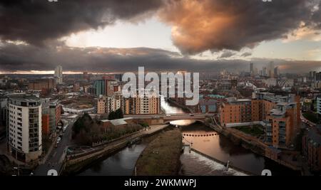 Ein fantastischer Panoramablick auf die Skyline der Stadt Leeds mit Leeds Dock und dem Fluss Aire, der durch die Stadt führt, mit dramatischem Himmel bei Sonnenuntergang Stockfoto