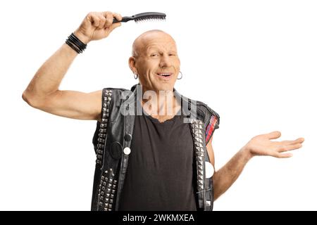 Fröhlicher kahler Mann, der eine Haarbürste über dem Kopf hält und isoliert auf weißem Hintergrund lächelt Stockfoto