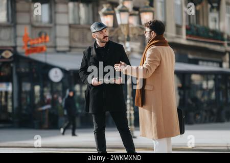 Zwei schicke Männer, die sich in einer Stadtstraße unterhalten. Stockfoto