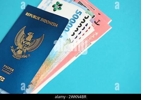 Blauer Indonesien Pass mit Geld und Flugtickets auf blauem Hintergrund Nahaufnahme. Tourismus und Reisekonzept Stockfoto