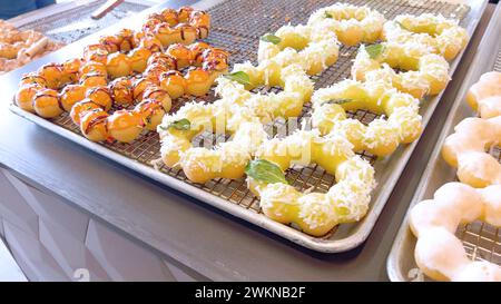 Verschiedene Mochi Donuts auf Backblechen, bereit zum Genießen Stockfoto